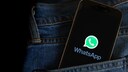 Smartphone with WhatsApp logo in a pants pocket