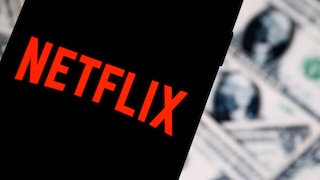Netflix logo on a smartphone with U.S. dollar bills in the background