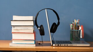 Headphones on Laptop with Stack of Books