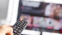 Person points a remote control at a television