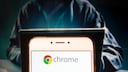 Smartphone with Chrome logo, a hacker in the background.