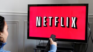 Woman Points Remote at TV with Netflix
