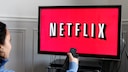 Woman Points Remote at TV with Netflix
