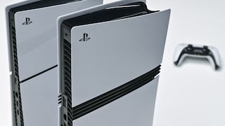 Two white PlayStation 5 consoles with controllers