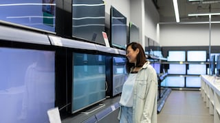 Woman Stands in Electronics Store in Front of TVs