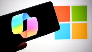 Smartphone with Copilot logo and Windows logo in the background