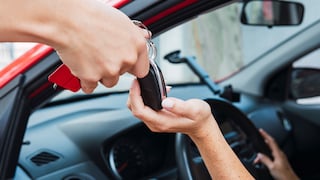 The seller hands the car keys to the customer.
