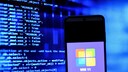 Smartphone with Windows logo and codes in the background