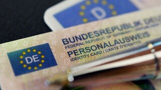 A German Federal Republic ID card is placed on top of a driver's license.