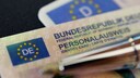 A German Federal Republic ID card is placed on top of a driver's license.