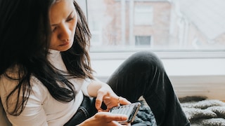 Woman looks worriedly at her smartphone