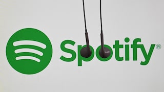 Spotify logo with in-ear headphones hanging over it