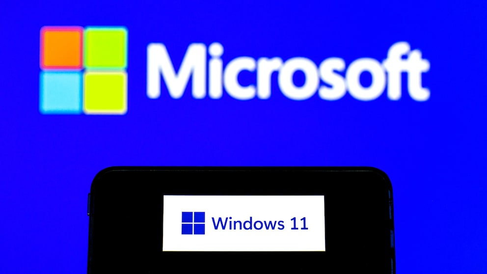 Smartphone Displays Windows 11 Logo Against Microsoft Background