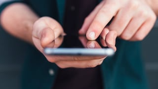 Man with a smartphone in hand and a finger on the display.