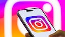 iPhone Displays Instagram Logo Against Instagram Logo Background