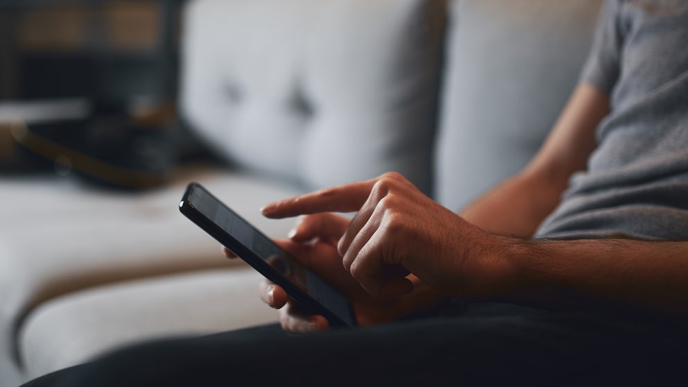 Man on Sofa Typing on iPhone
