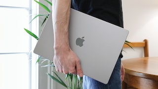 Man Carries MacBook Under His Arm
