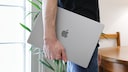 Man Carries MacBook Under His Arm