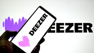 Smartphone with Deezer logo in front of a larger Deezer logo.
