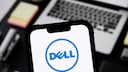 Smartphone with Dell logo, with a notebook in the background.