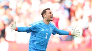 Manuel Neuer, wearing a blue jersey, runs jubilantly across a soccer field.