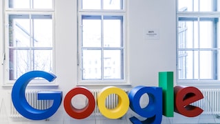 Google logo in front of a residential building's windows.