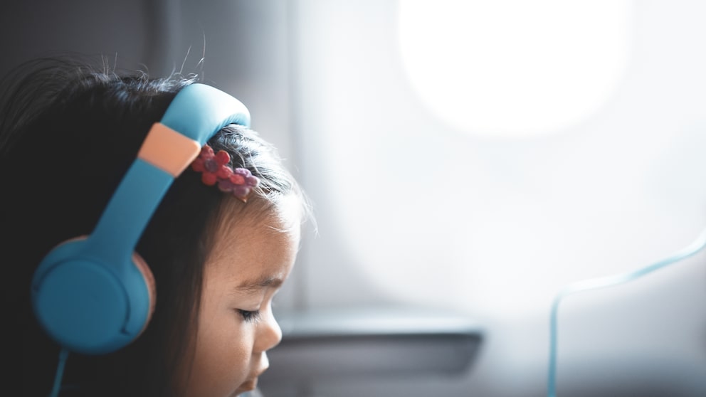 Young Girl on Airplane Wearing Headphones