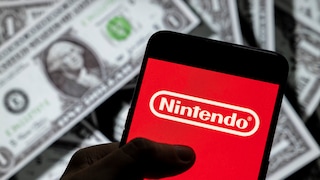 Smartphone with Nintendo logo, with a stack of U.S. dollars in the background.