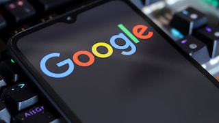 Smartphone with Google logo resting on a keyboard.