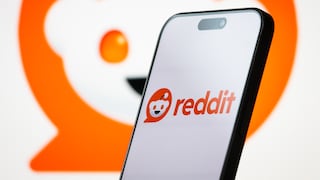 Smartphone with Reddit logo in the foreground. In the background, a large Reddit logo.