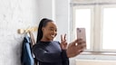 Young dark-skinned woman taking a selfie and flashing the peace sign.