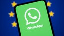 Smartphone with WhatsApp logo in the foreground. In the background, the European Union flag.