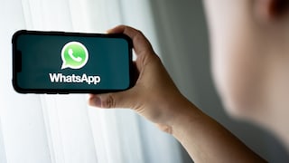 Person with a smartphone displaying the WhatsApp logo.