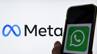 Smartphone with WhatsApp logo in the foreground. In the background, the Meta logo.
