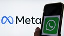Smartphone with WhatsApp logo in the foreground. In the background, the Meta logo.