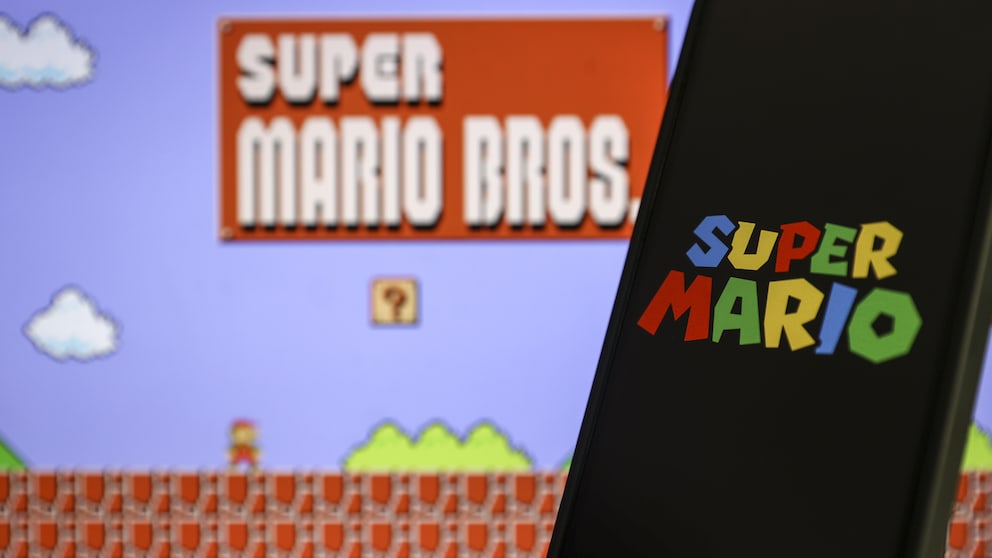 Smartphone with Super Mario logo in the foreground. In the background, the Super Mario Bros. logo.