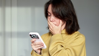 Shocked Woman Holding an iPhone