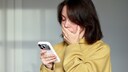 Shocked Woman Holding an iPhone