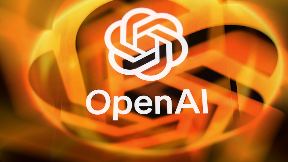The OpenAI logo appears in white against a blurred background of orange and yellow light streaks. Below the logo, the word "OpenAI" is displayed in white lettering. The image is dominated by warm orange tones and, due to the strong blur in the background, has an abstract feel.