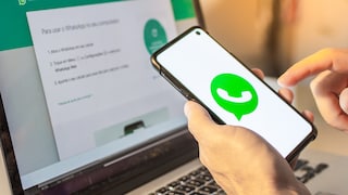 WhatsApp logo on smartphone in front of WhatsApp Web on laptop