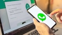 WhatsApp logo on smartphone in front of WhatsApp Web on laptop