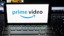 Logo for Amazon Prime Video on a smartphone resting on a laptop