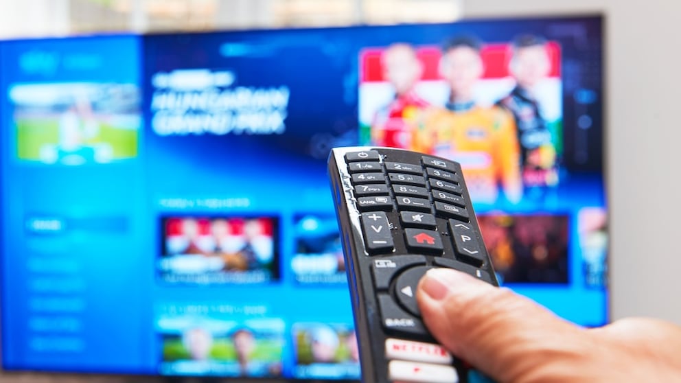 Person points a remote control at a television