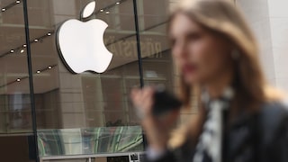 Apple Logo Above Store Entrance, Woman with Smartphone in Foreground