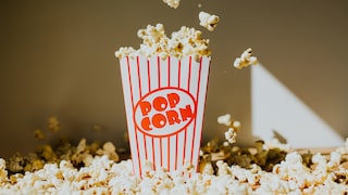 Popcorn bucket surrounded by lots of popcorn