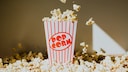 Popcorn bucket surrounded by lots of popcorn