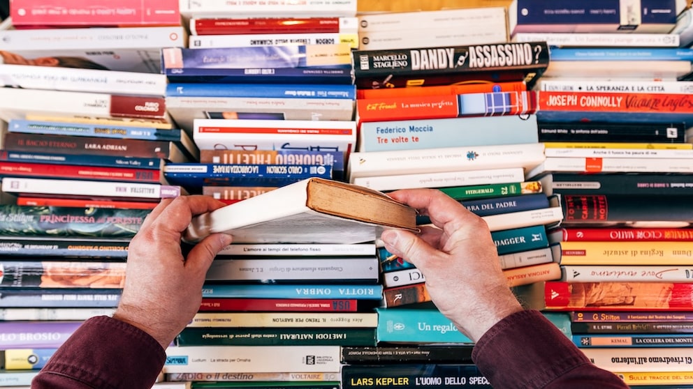 Person Digs Through Several Books