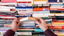 Person Digs Through Several Books