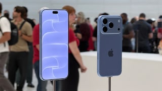 Two blue Apple smartphones are displayed on metal stands in a brightly lit showroom. On the left, the front with the screen turned on is visible, while on the right, the back with three camera lenses is shown. In the blurred background, several people and additional display areas can be seen.