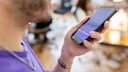 Close-up of someone speaking into the voice assistant on their smartphone